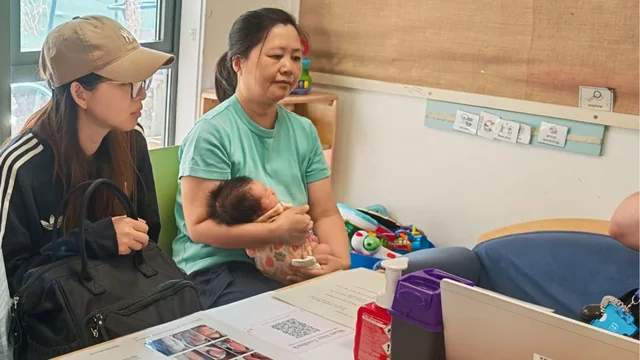 Jenny accompanying a mother and baby to a health check-up