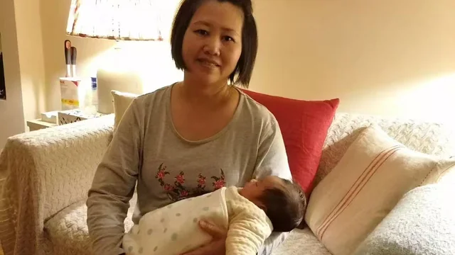Jenny settling a swaddled newborn