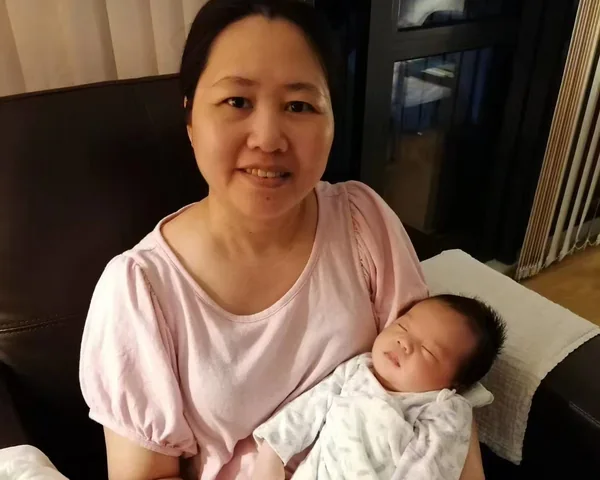 Jenny holding a sleeping newborn so the mother can rest